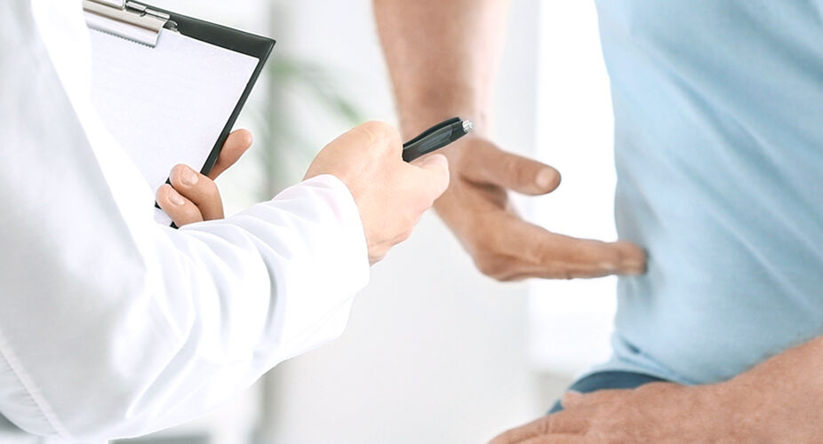 Ein Arzt untersucht einen Patienten, der ein blaues T-Shirt trägt. Der Arzt hält ein Tablet oder ein digitales Gerät in der Hand und steht in einem hellen, modernen Raum. Der Fokus liegt auf der ärztlichen Untersuchung des Patienten.