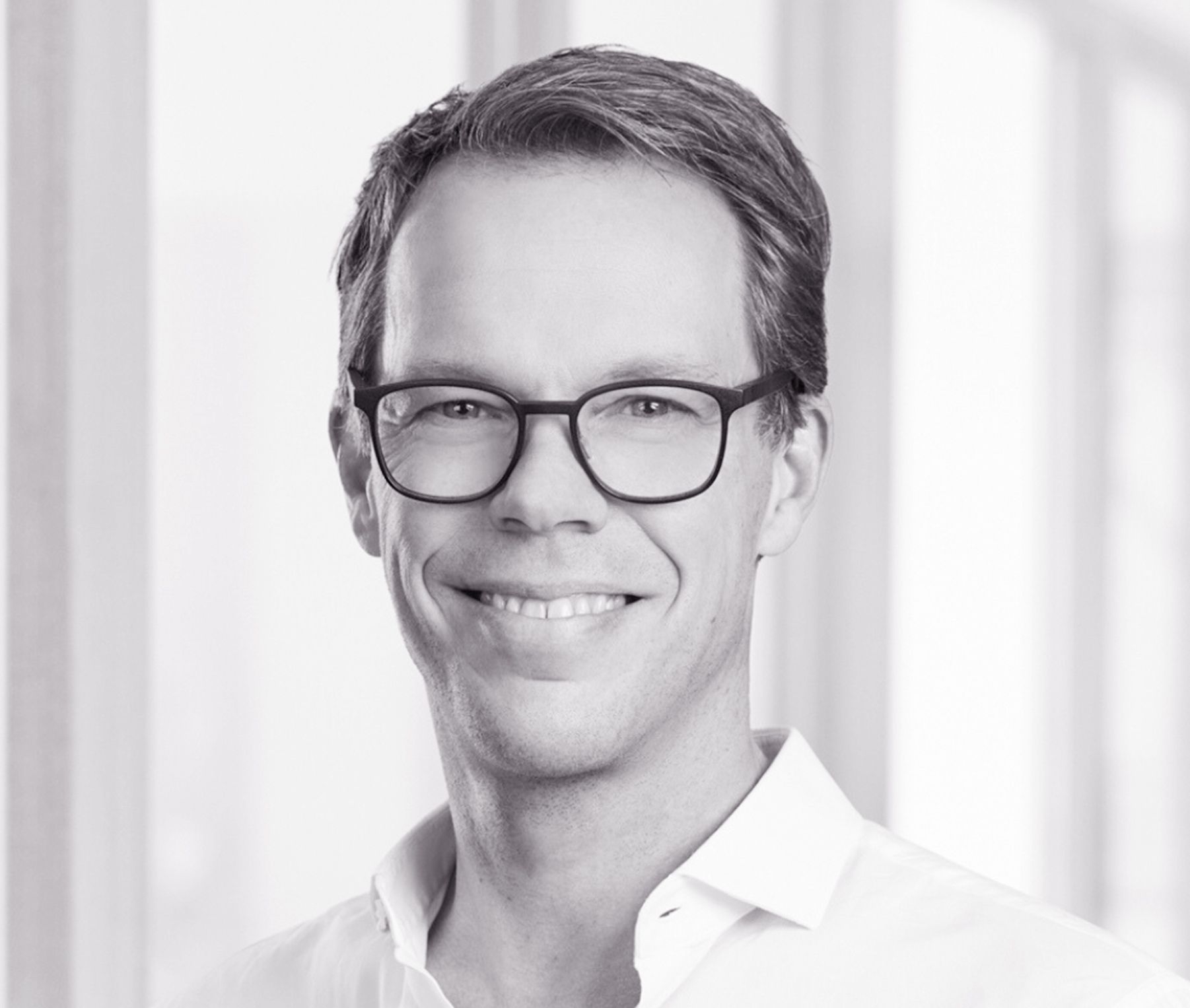 Porträt eines Mannes mit Brille und lächelnd Schwarze und weiße Porträtaufnahme