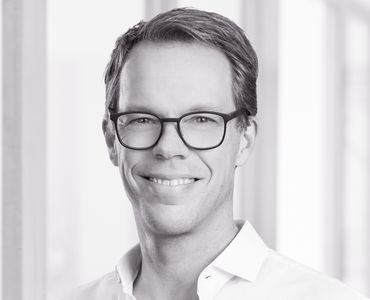 Porträt eines Mannes mit Brille und lächelnd Schwarze und weiße Porträtaufnahme