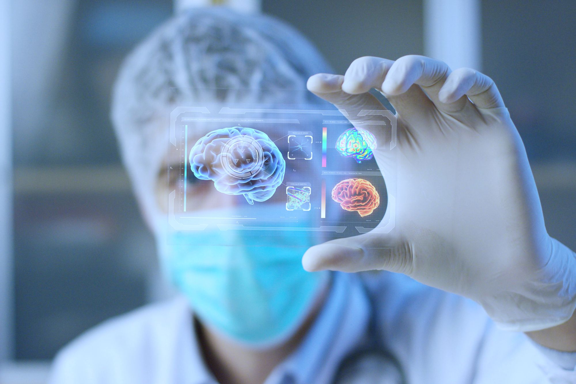 A medical professional in a mask holds a transparent digital display showing holographic images of human brains. The setting suggests a futuristic approach to brain research or diagnostics. The focus on the brain imagery highlights advancements in medical technology.
