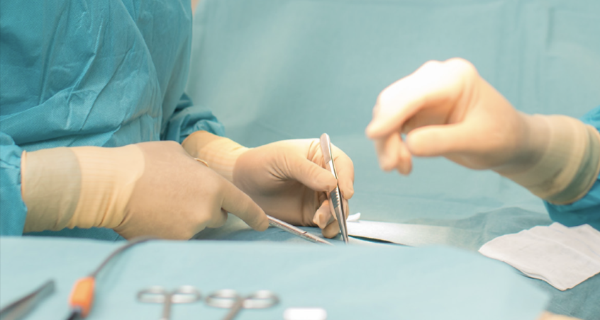 Two gloved hands perform a surgical procedure, with one hand holding a surgical instrument and the other preparing to assist. The scene is set on a surgical drape, emphasizing a focused medical environment.