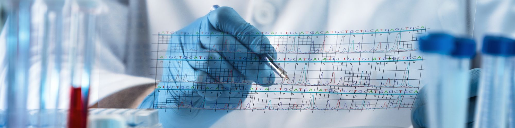 Eine Hand mit blauer Gummihandschuh hält einen Stift über ein Diagramm oder eine Tabelle. Im Hintergrund sind Reagenzgläser zu sehen, die möglicherweise für wissenschaftliche Experimente genutzt werden.